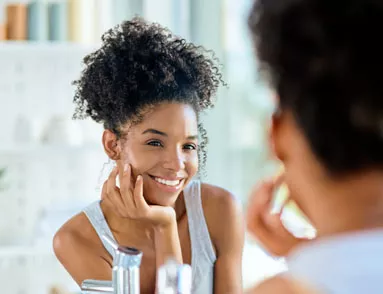 Woman admiring smile in mirror